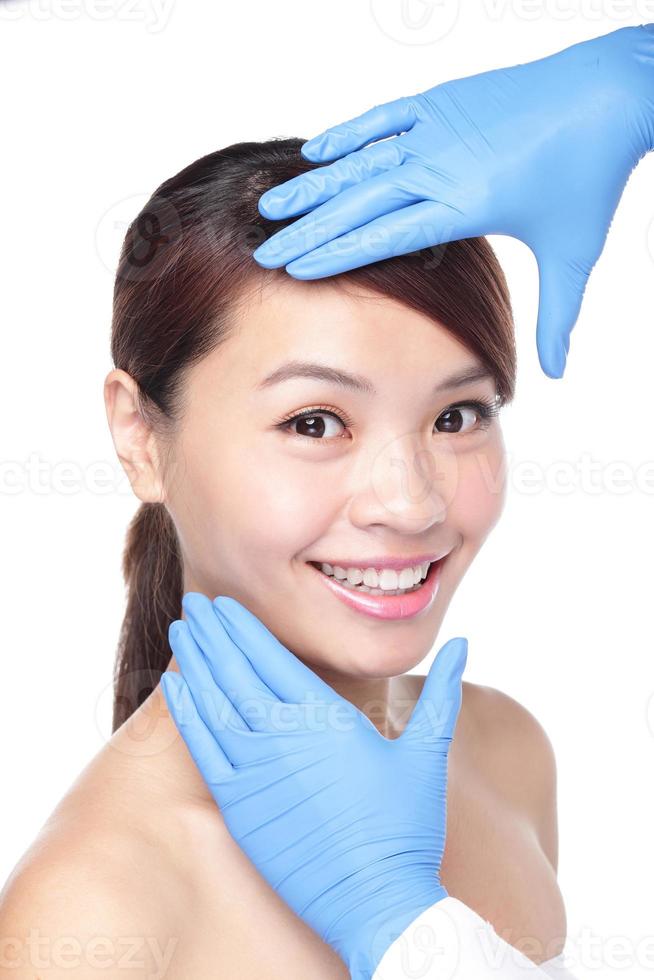 schönes weibliches Gesicht mit Handschuh der plastischen Chirurgie foto