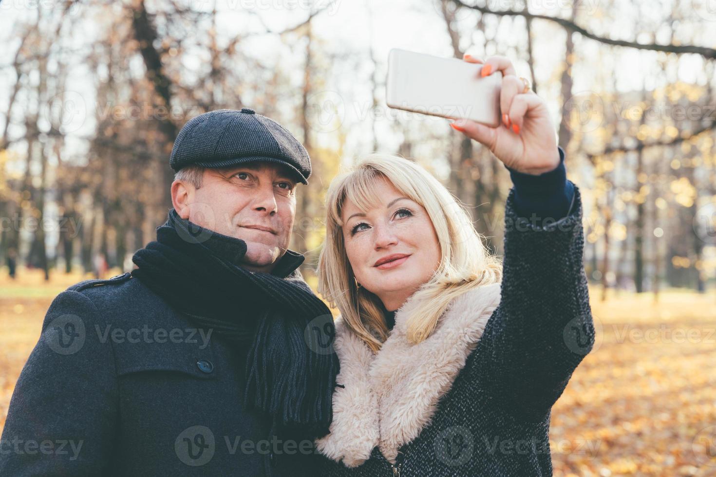 glückliche blonde reife Frau und hübscher brünetter Mann mittleren Alters foto