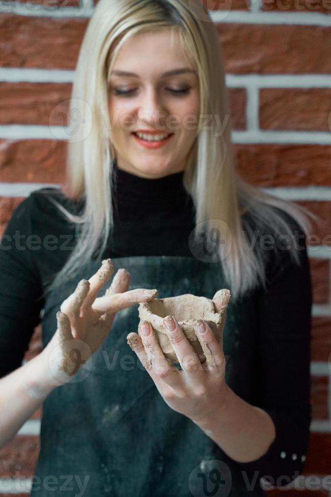 Lächelnde und glückliche Frau, die Keramikschale in der Hand macht. kreatives hobbykonzept. nebenbei geld verdienen, hobbys zu geld machen, leidenschaft zum beruf, vertikal foto