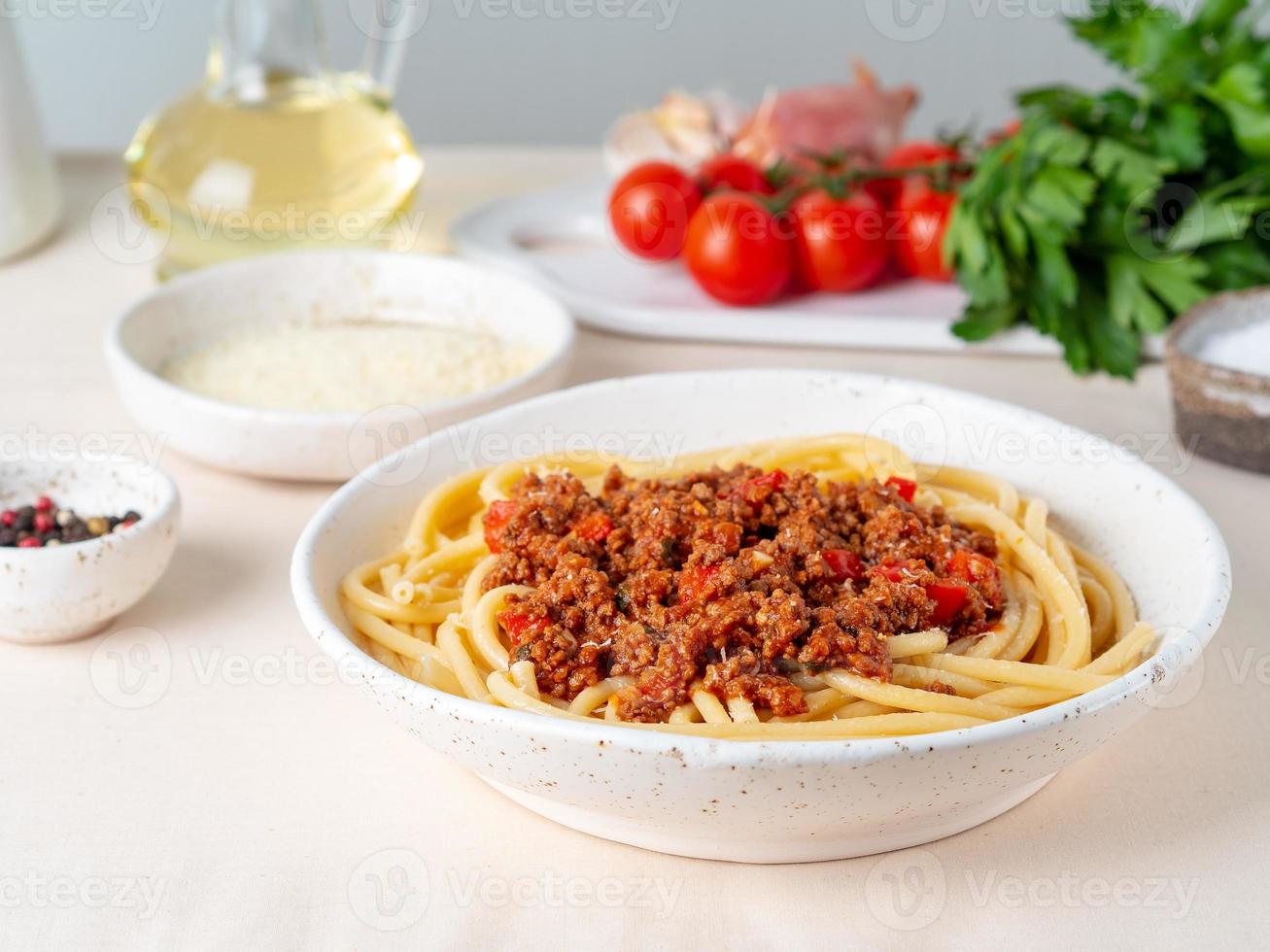 Pasta Bolognese mit Tomatensauce, Rinderhackfleisch, Basilikumblätter im Hintergrund foto