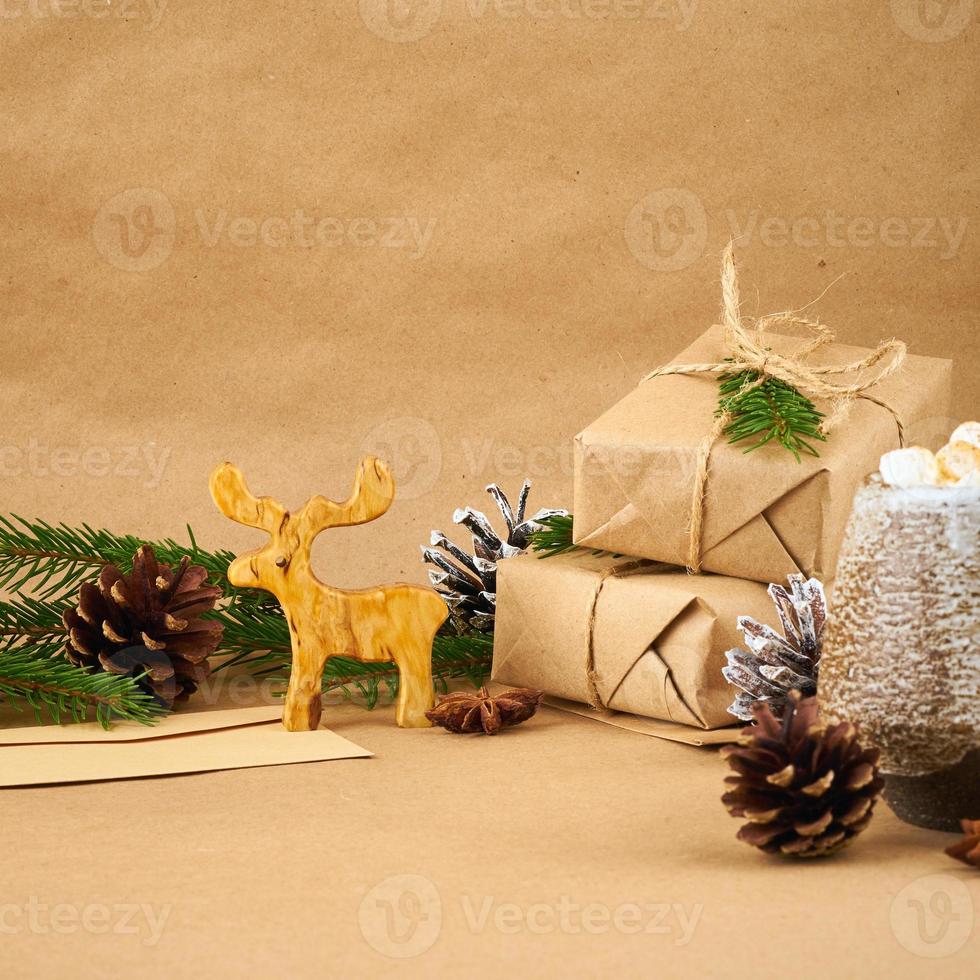 weihnachten und frohes neues jahr null abfall handwerk papier hintergrund. handgemachte geschenkweihnachtsbox, tannenzweige, tasse mit heißer schokolade, marshmallows, seitenansicht, kopierraum. umweltfreundliches plastikfreies konzept foto