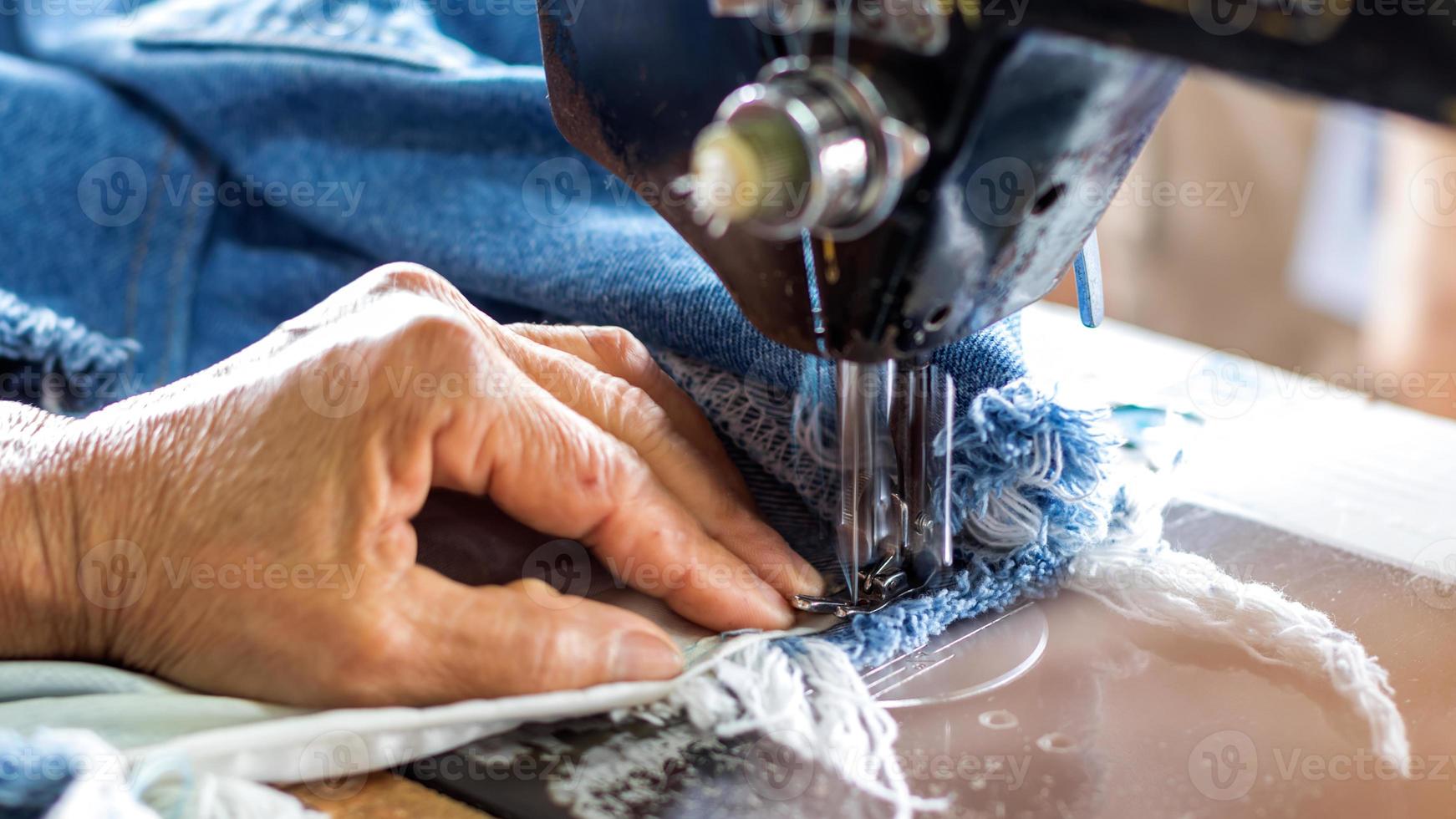 Repariere Jeans mit einer alten Nähmaschine. foto