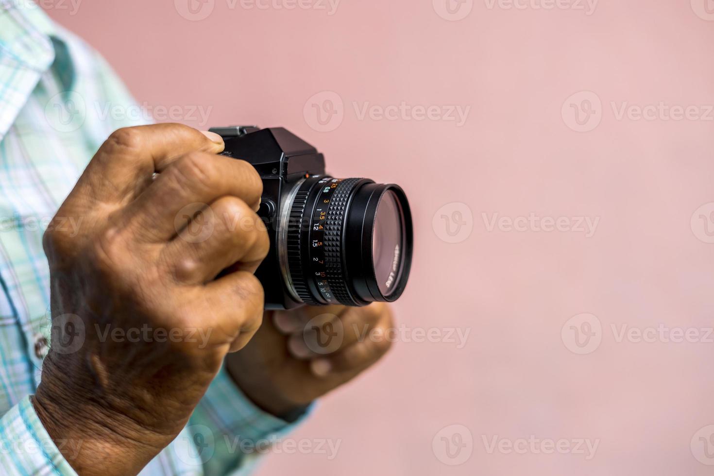 Beide Hände eines älteren Thailänders, der eine alte Filmkamera hält. foto