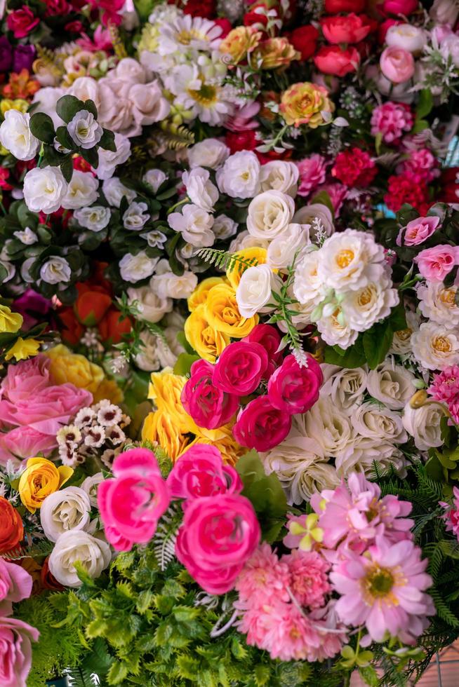 Hintergrund vieler bunter künstlicher gefälschter Blumen, die schön blühen. foto