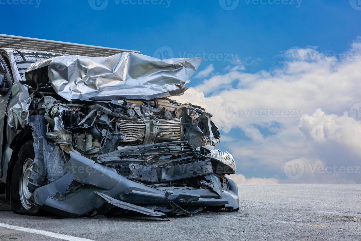 eine Nahaufnahme der Front eines schwarzbronzenen Autos, das bei einer Kollision mit einem anderen Fahrzeug zerstört wurde. foto