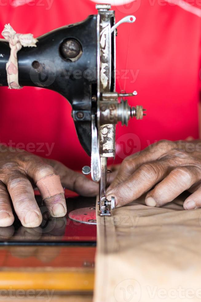 ältere hand mit einer nähmaschine. foto