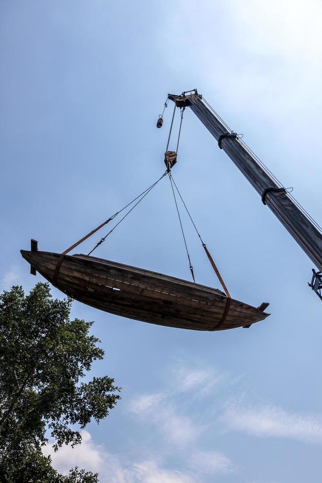 Alte verfallene Holzboote werden mit Kränen und Drahtseilen bewegt. foto