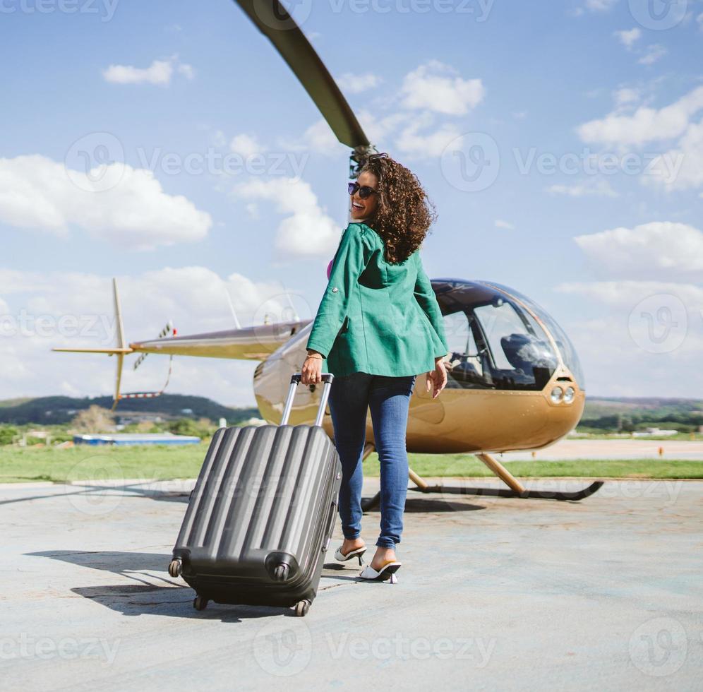 erfolgreiche, elegante, junge lateinische frau in der nähe des hubschraubers. Luxus-Lifestyle-Konzept foto