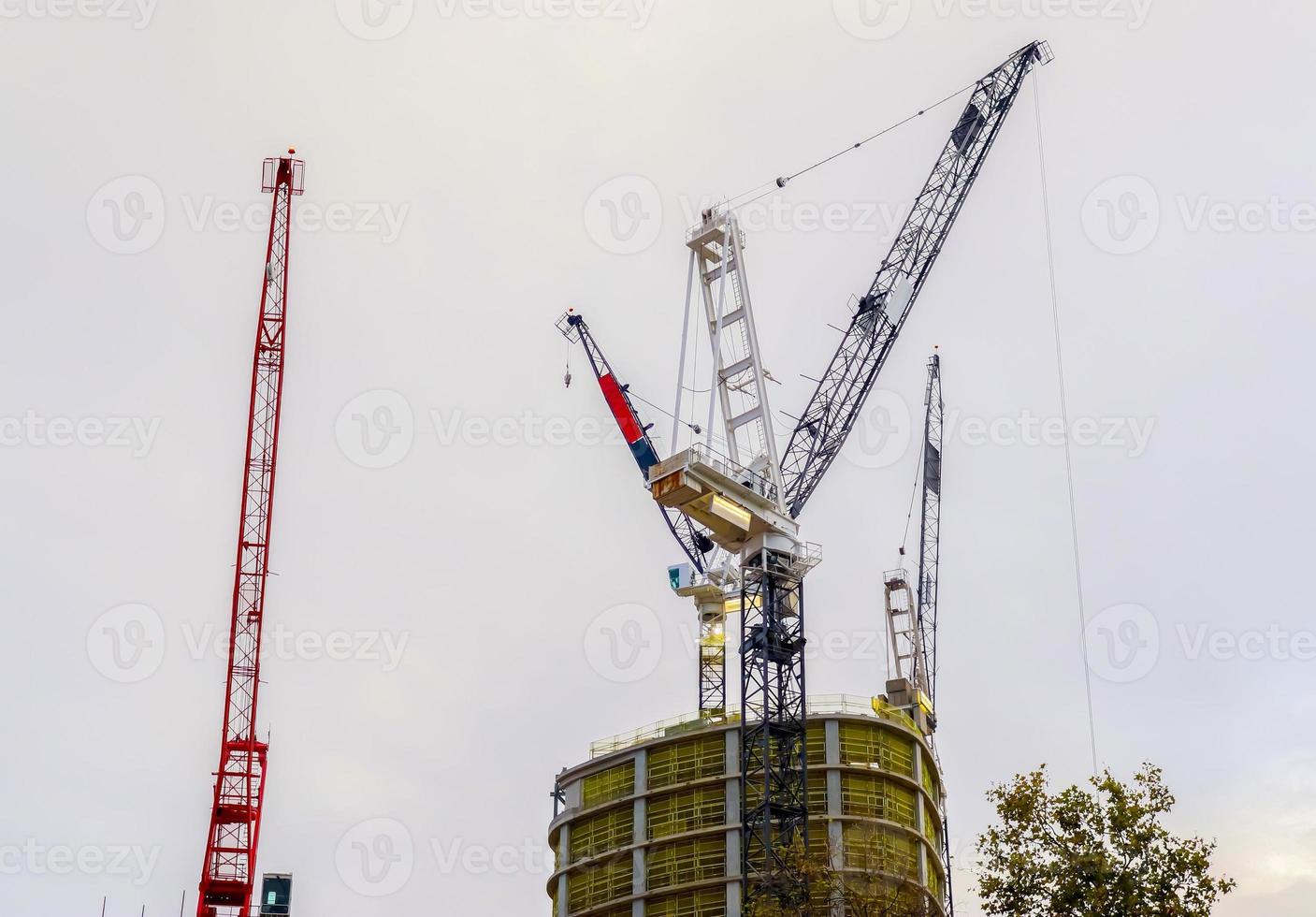 Mehrere Kräne auf Baustellen an hohen Gebäuden in ganz Europa foto