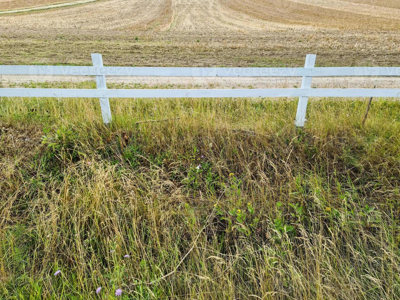 Schöner hölzerner Pferdezaun auf einem landwirtschaftlichen Feld an einem Sommertag. foto