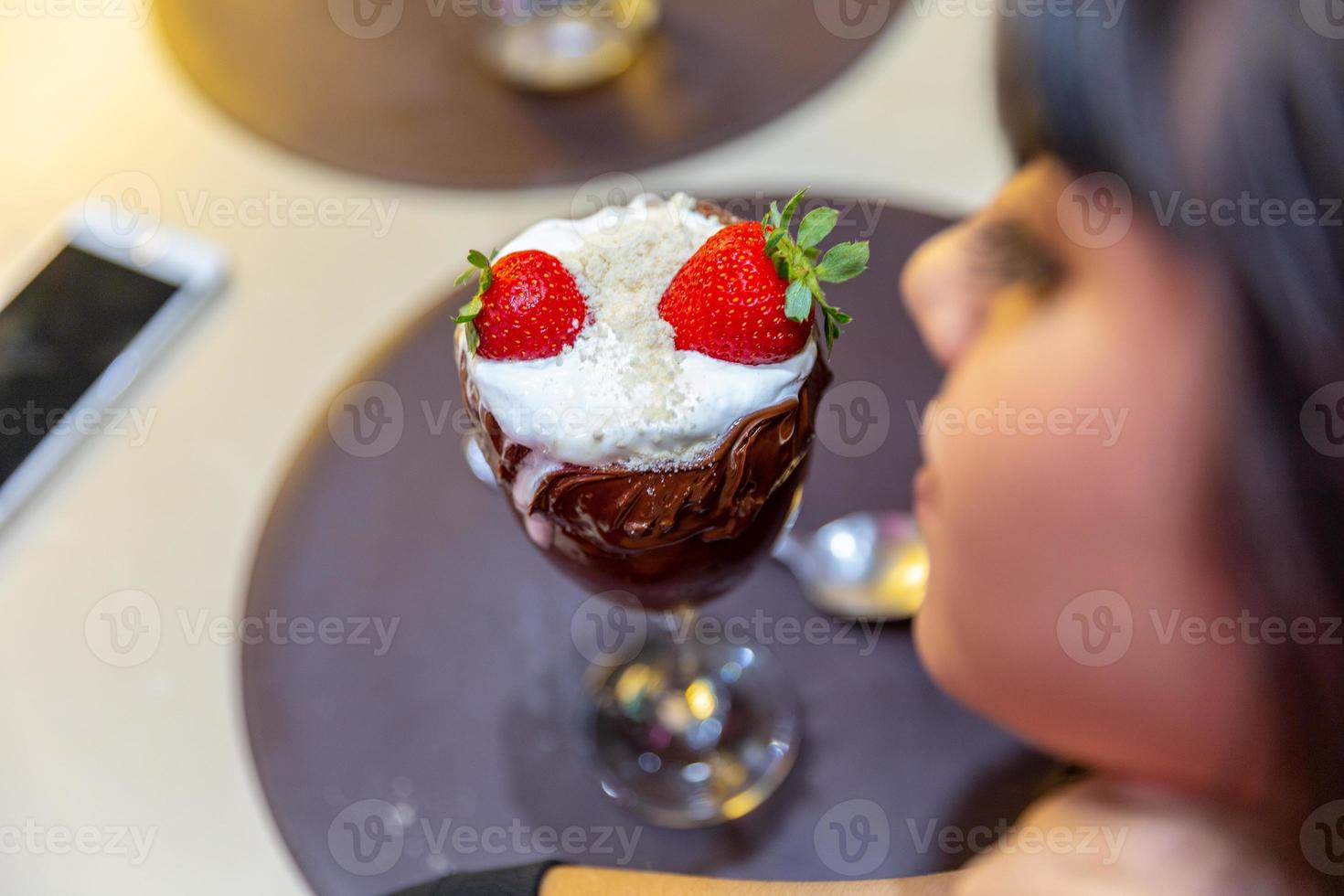 Eiscremeweiß mischt Erdbeere mit hohen Kalorien, kann Sie fett machen, weicher Fokus, verschwommen. leckerer Vanille- oder Schokoladeneisbecher mit Erdbeere. foto