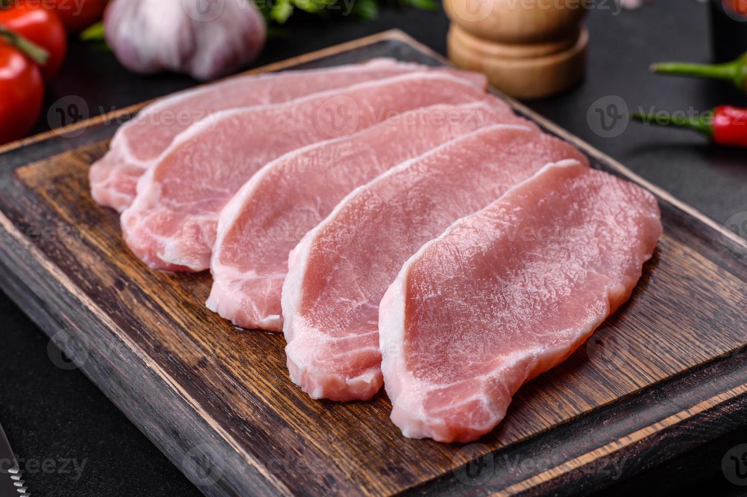 Rohes frisches Schweinefleisch, geschnitten auf einem Holzschneidebrett foto