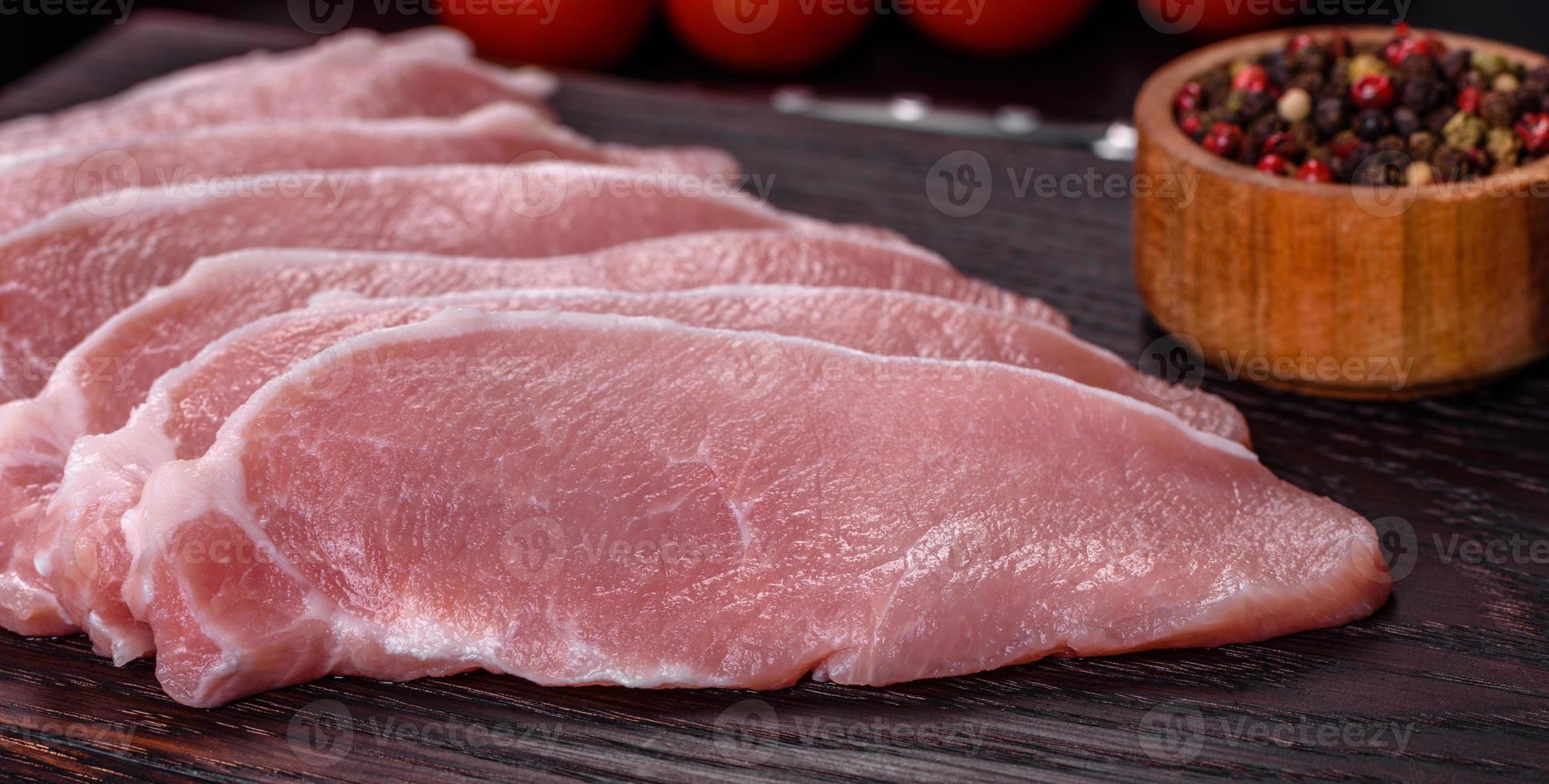 Rohes frisches Schweinefleisch, geschnitten auf einem Holzschneidebrett foto