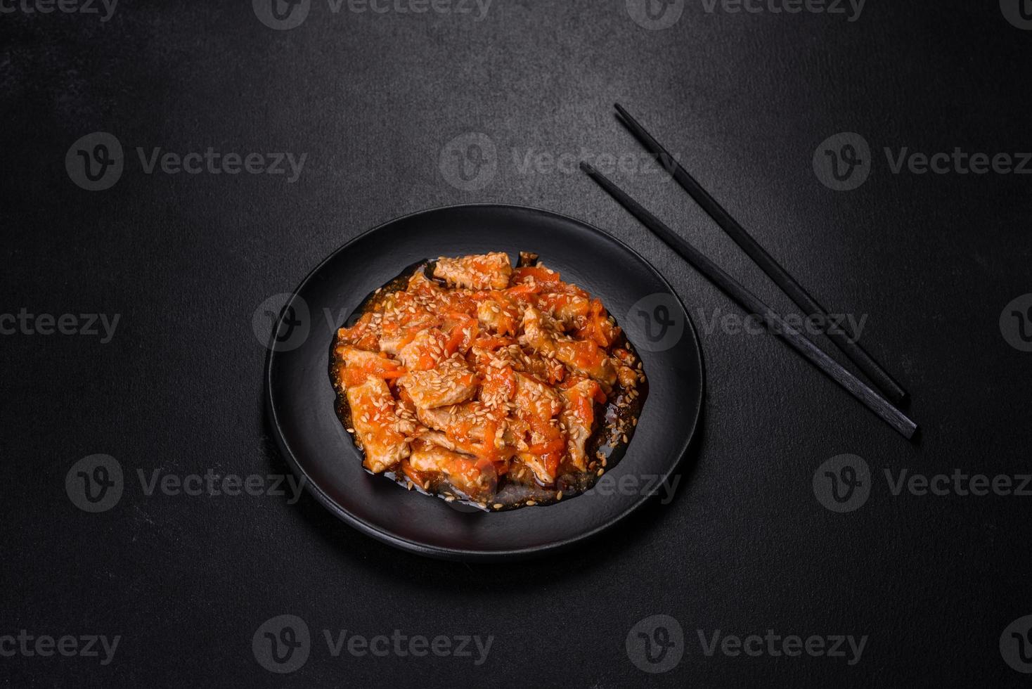 Teriyaki-Huhn mit Sauce, Sesam, Kräutern und Gewürzen auf dunklem Hintergrund foto