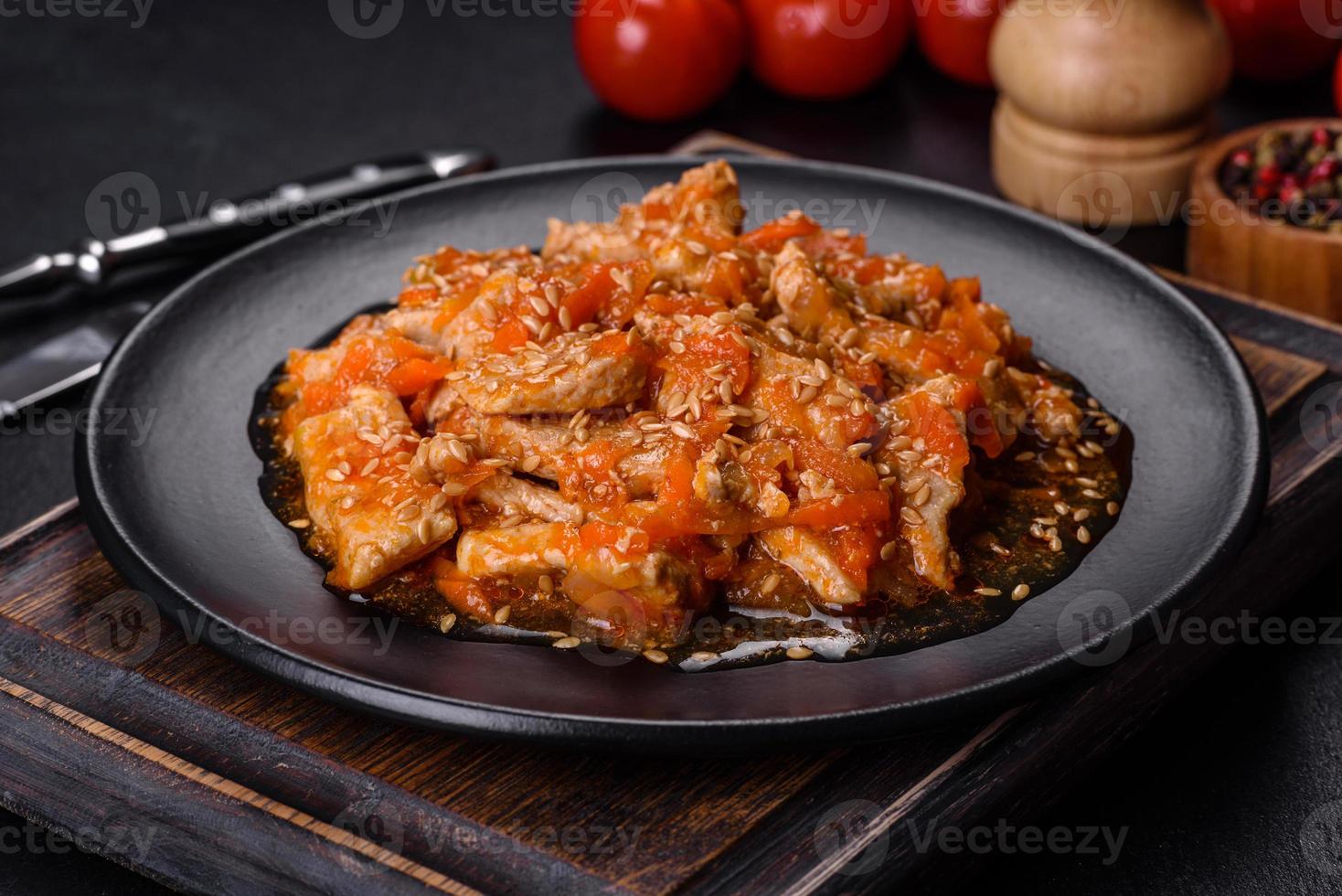 Teriyaki-Huhn mit Sauce, Sesam, Kräutern und Gewürzen auf dunklem Hintergrund foto