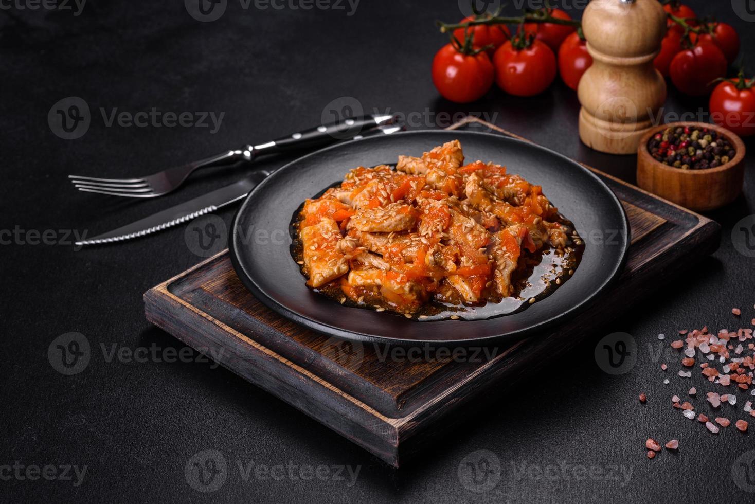 Teriyaki-Huhn mit Sauce, Sesam, Kräutern und Gewürzen auf dunklem Hintergrund foto