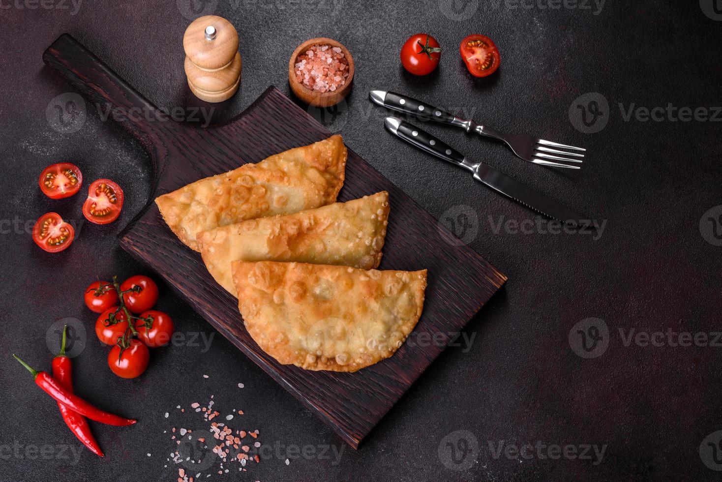 hausgemachte Chebureks gefüllt mit Hackfleisch und Zwiebeln, traditionelle kaukasische Küche foto