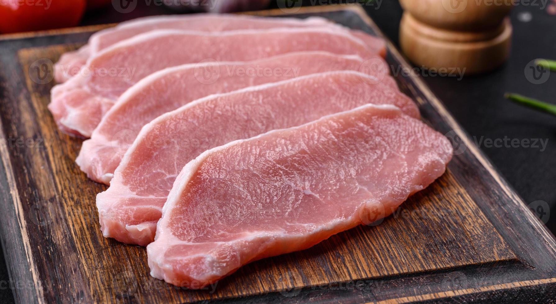 Rohes frisches Schweinefleisch, geschnitten auf einem Holzschneidebrett foto