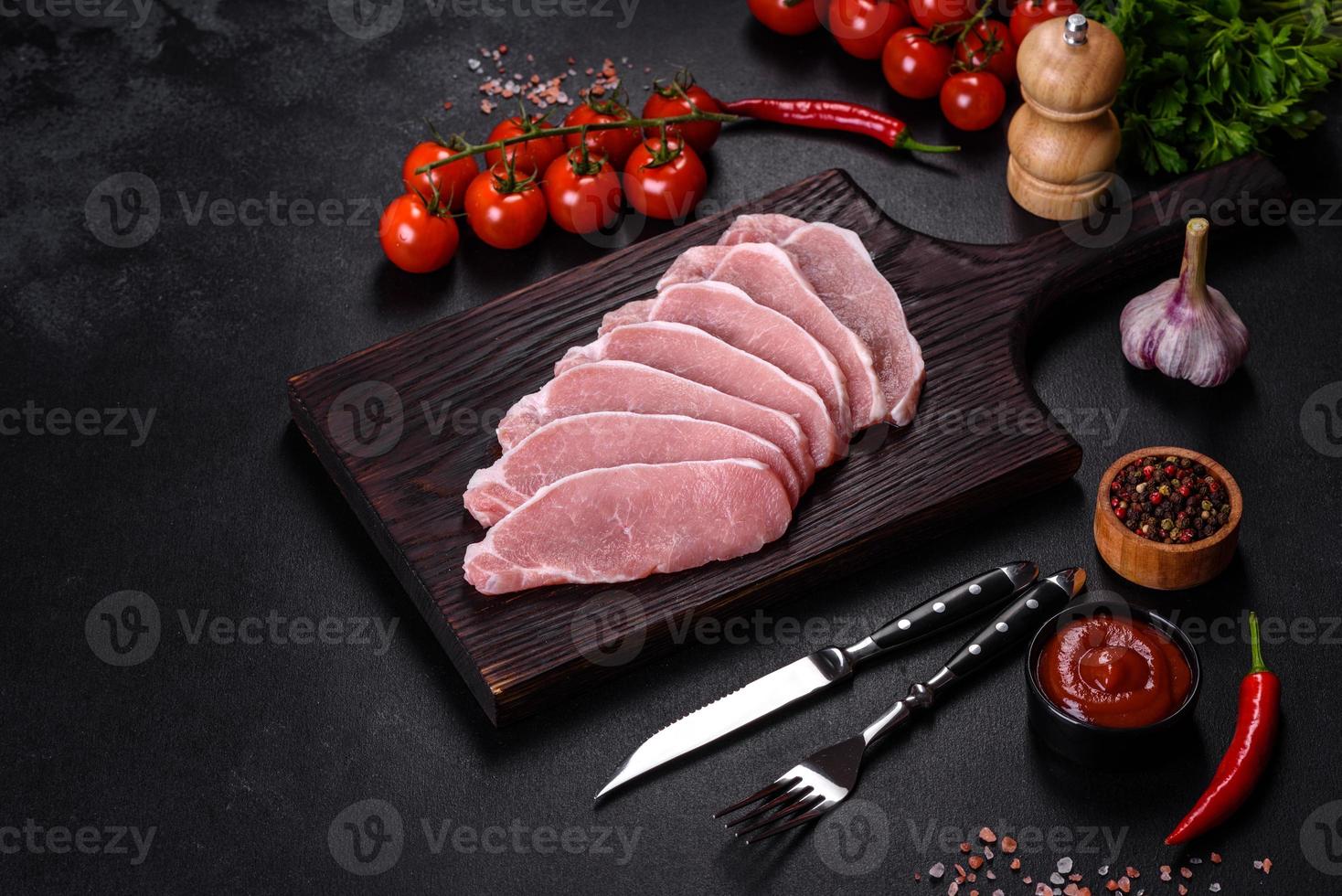 Rohes frisches Schweinefleisch, geschnitten auf einem Holzschneidebrett foto