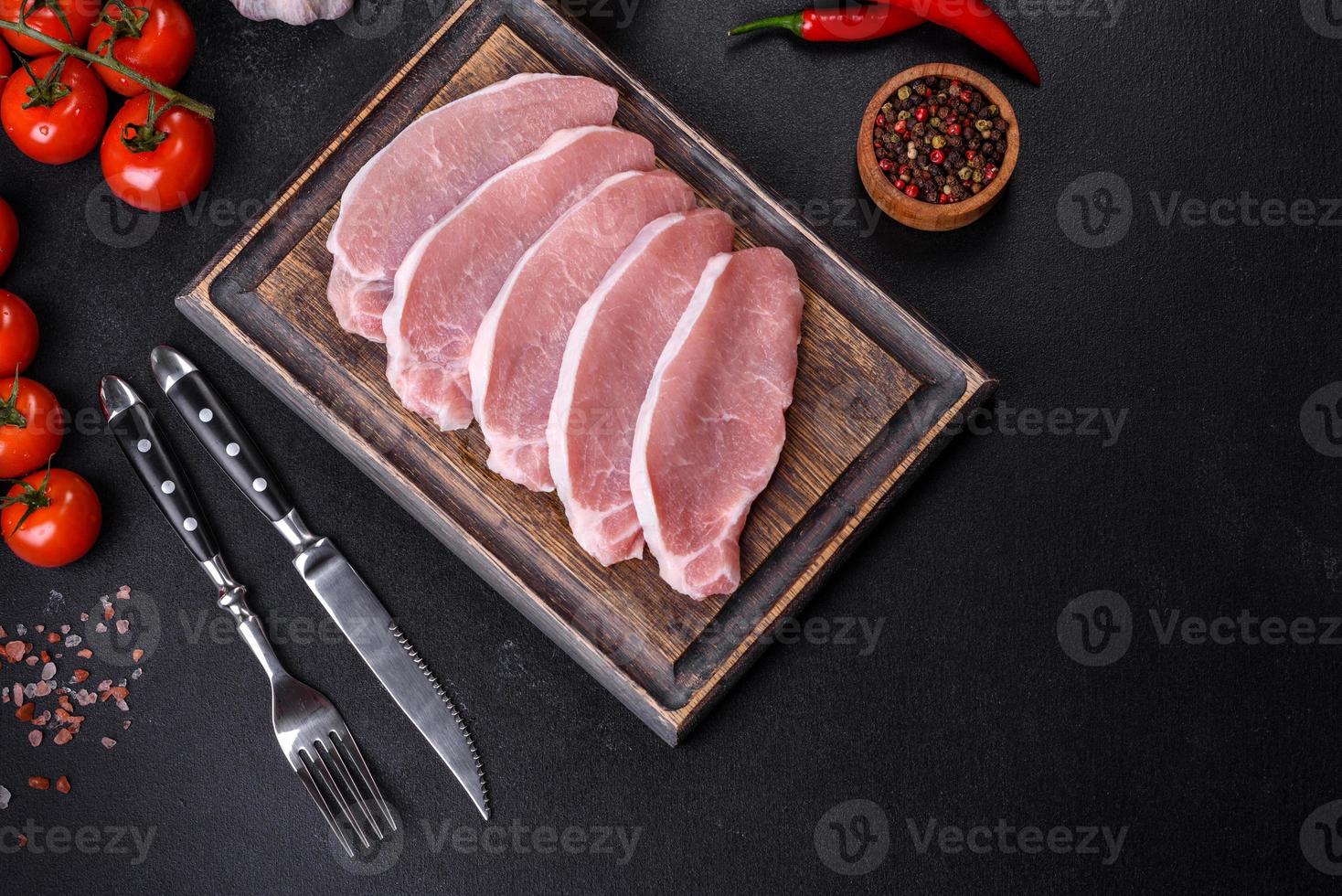 Rohes frisches Schweinefleisch, geschnitten auf einem Holzschneidebrett foto