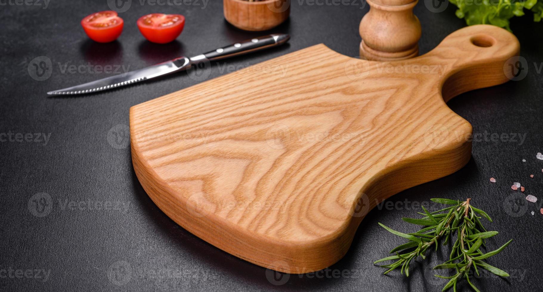 ein Holzschneidebrett mit einem Küchenmesser mit Gewürzen und Kräutern foto