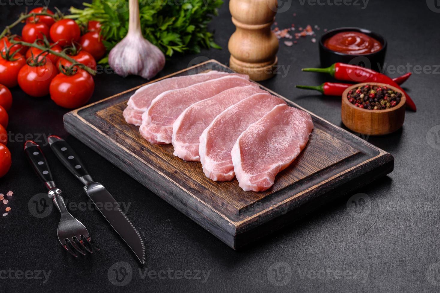 Rohes frisches Schweinefleisch, geschnitten auf einem Holzschneidebrett foto