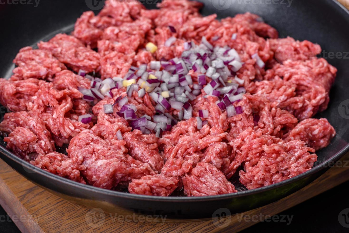 frisches rohes hackfleisch mit gewürzen und kräutern auf dunklem betonhintergrund foto