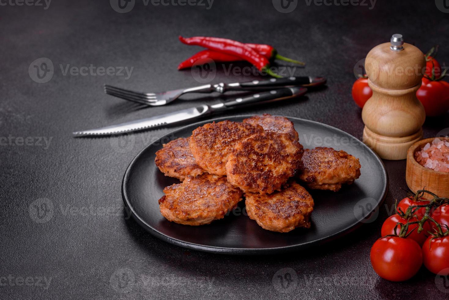 Fischkuchen. Fischbrötchen. Gebratene Koteletts aus gehacktem Fisch auf einem schwarzen Teller foto