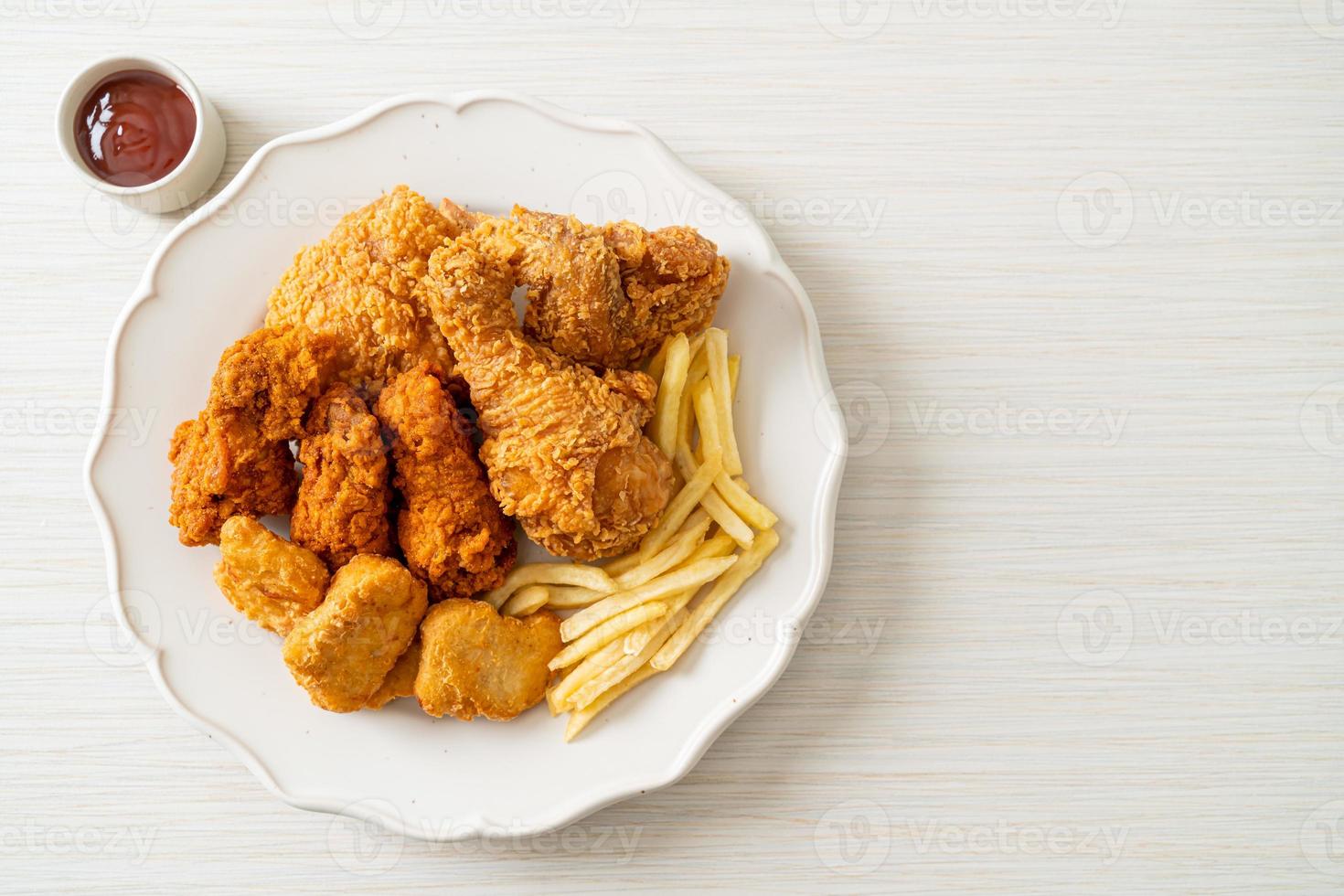 Brathähnchen mit Pommes Frites und Nuggets auf Teller foto