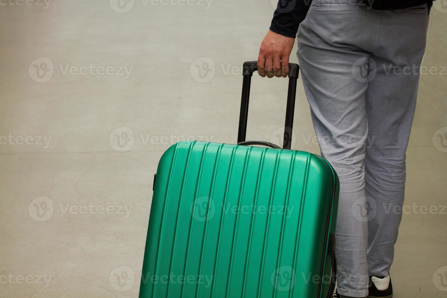 am Flughafen warten. das konzept der sommerferien, ein reisender mit koffer im wartebereich des flughafenterminals. selektiver Fokus. foto