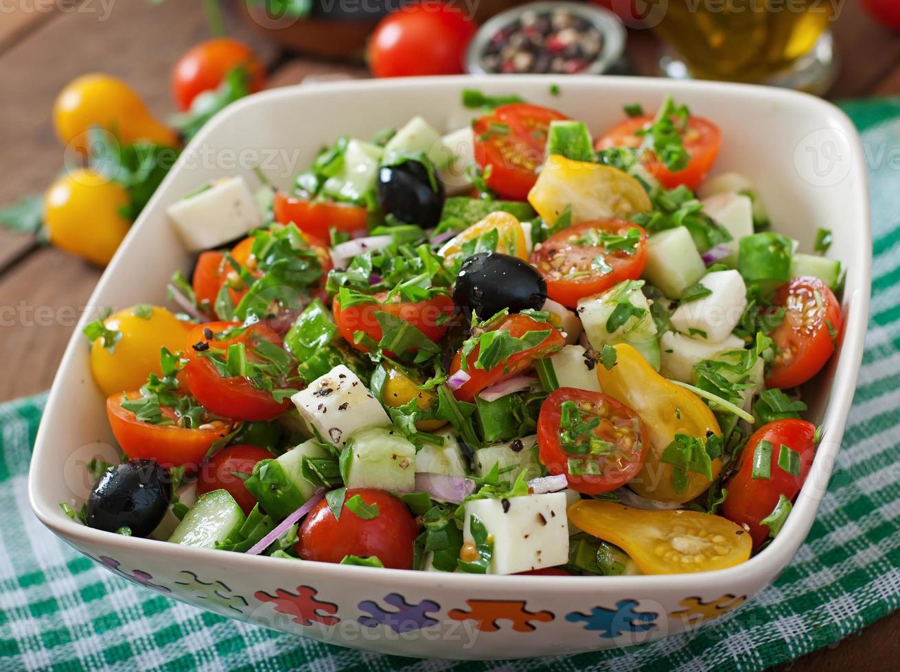 Griechischer Salat mit frischem Gemüse, Feta-Käse und schwarzen Oliven foto