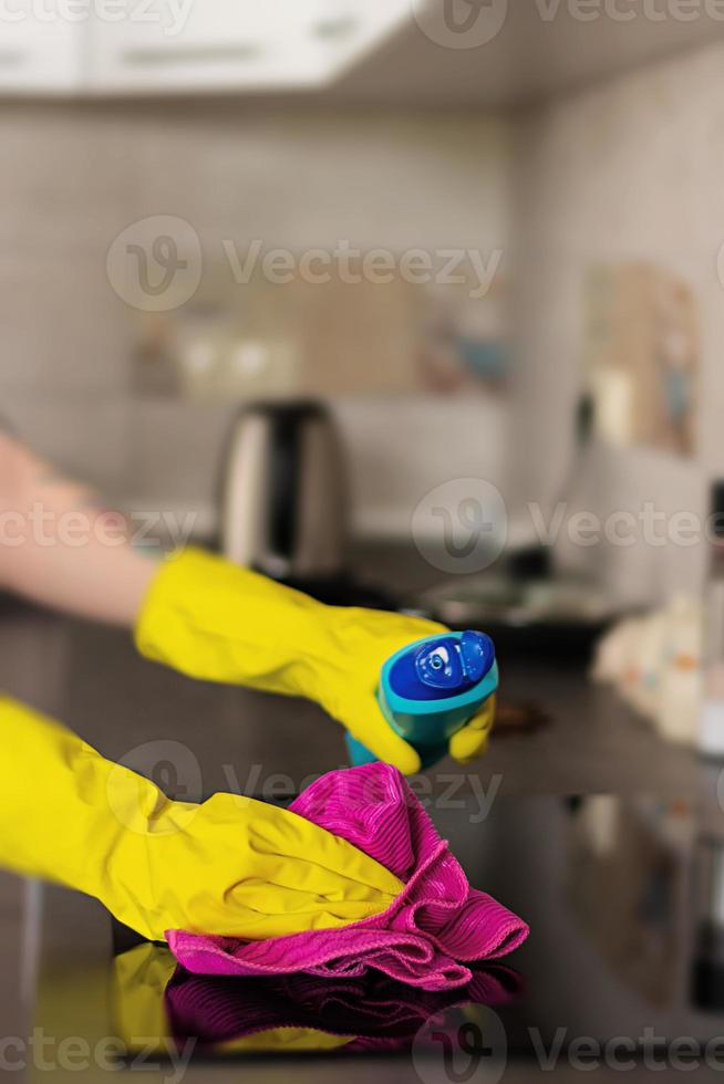 frau in schutzhandschuhen, die staub mit reinigungsspray und staubtuch abwischen. Reinigungsservice-Konzept. foto