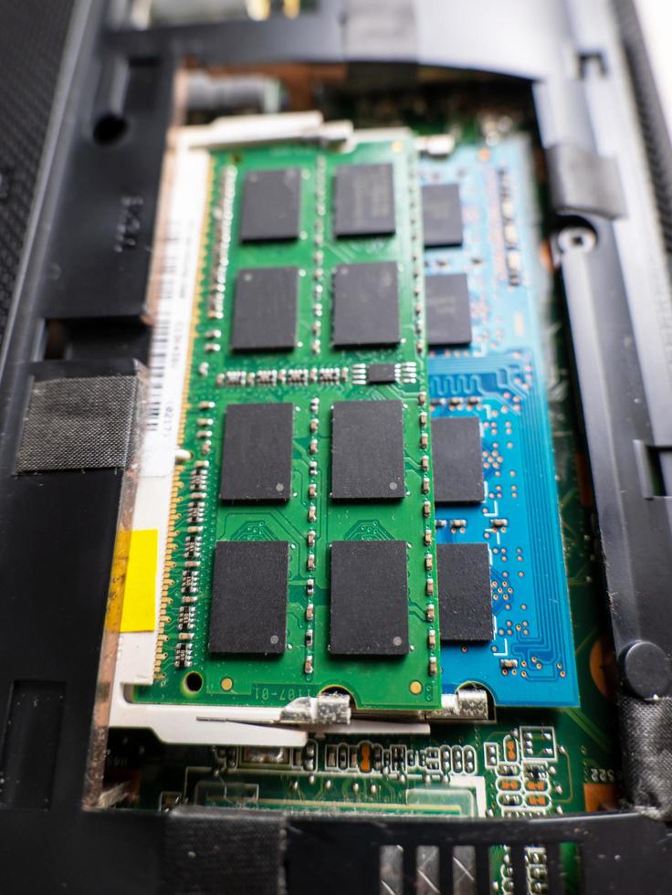 Laptop mit offenem Deckel, um es zu reparieren, Sie werden einen DDR-RAM mit einem Chip sehen, warten Sie auf die Notebook-Überprüfung, Sie werden das Motherboard ein wenig sehen. Sie werden sehen, dass Staub darin ist. foto