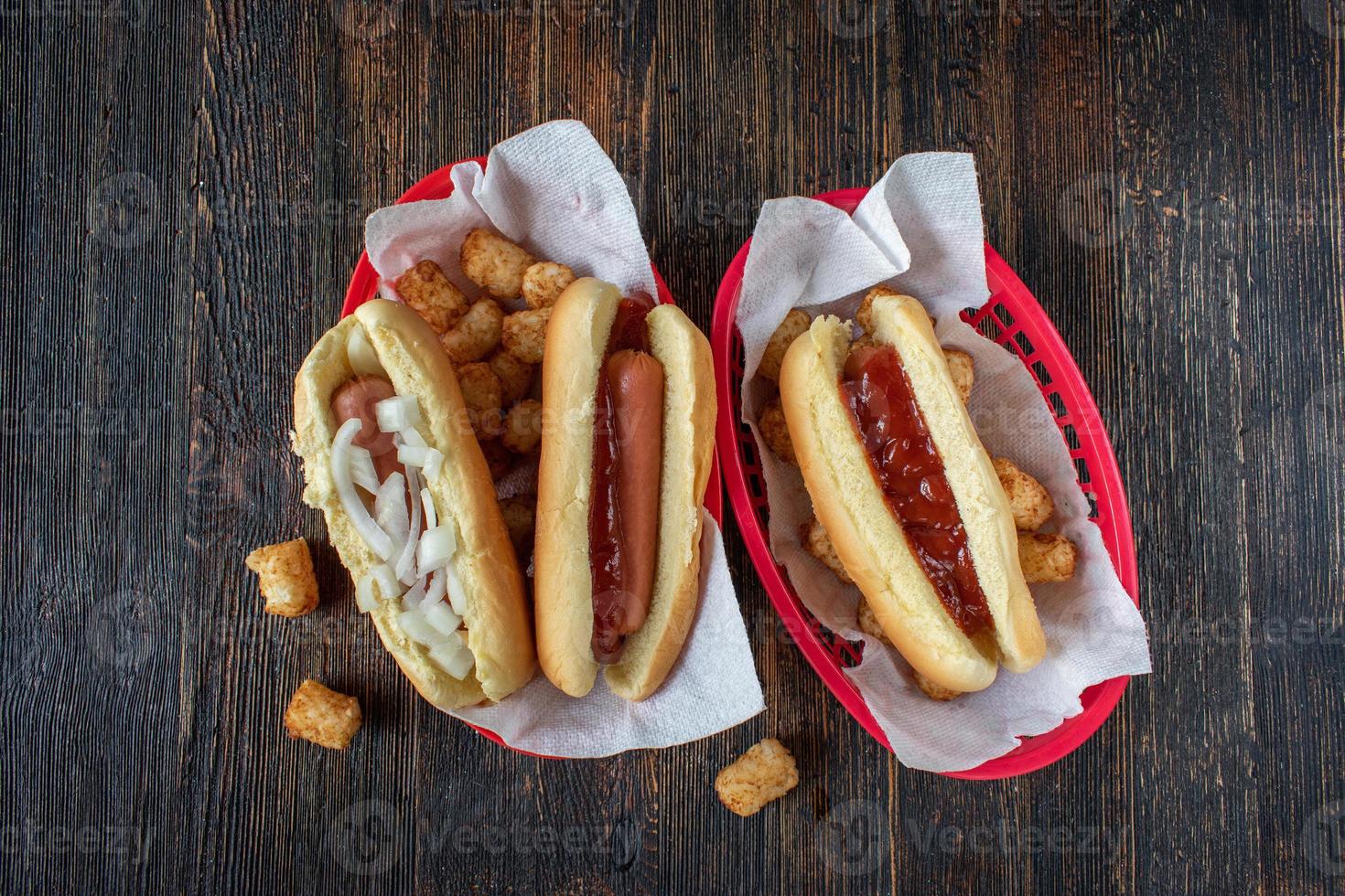 Blick von oben auf gekleidete Hot Dogs mit tater Knirpsen in Körben foto