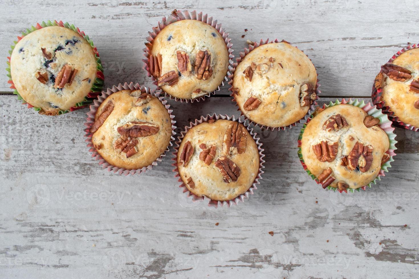 Gruppe gebackener Blaubeermuffins mit Pekannüssen mit Kopierraum foto