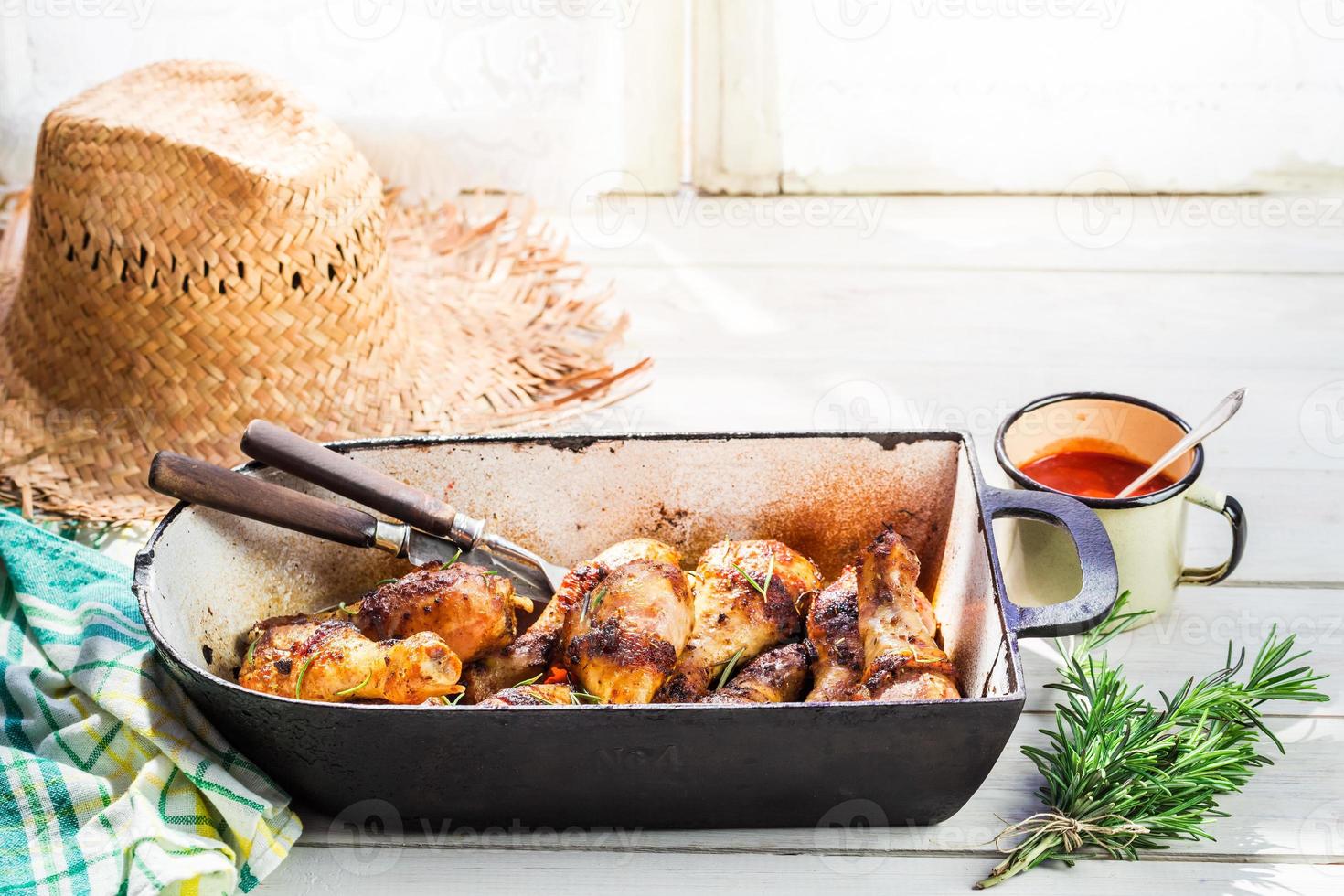 heiße Hähnchenschenkel mit Kräutern und Sauce in der Sommerküche foto