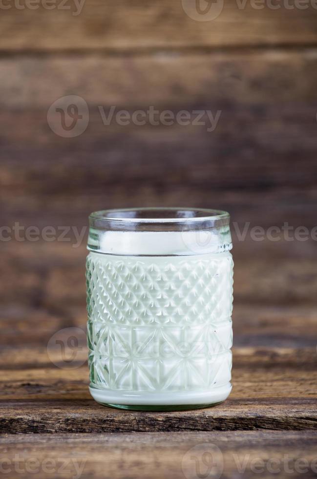 Glas Milch auf einem Holztisch foto