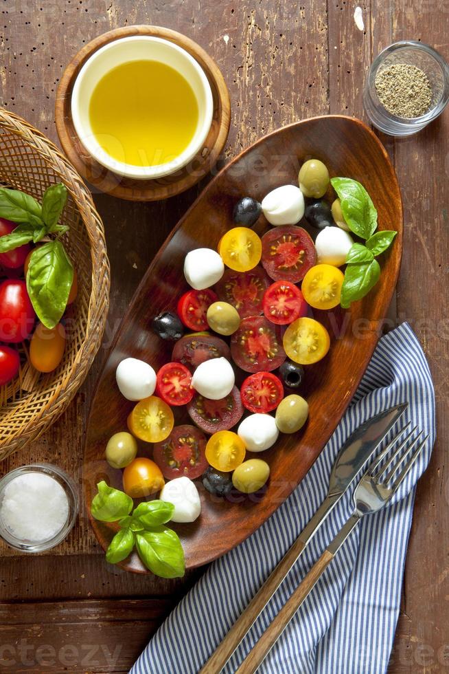 Salat mit farbigen Tomaten, kleinem Mozzarella, grünen Oliven und b foto