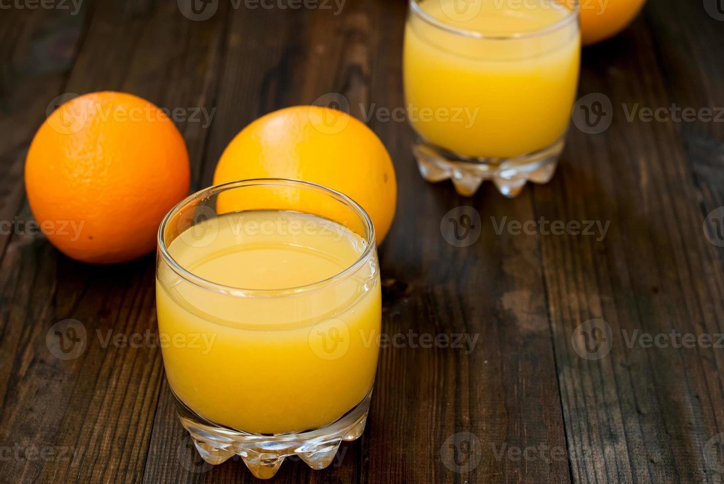 frischer Orangensaft auf Holztisch foto