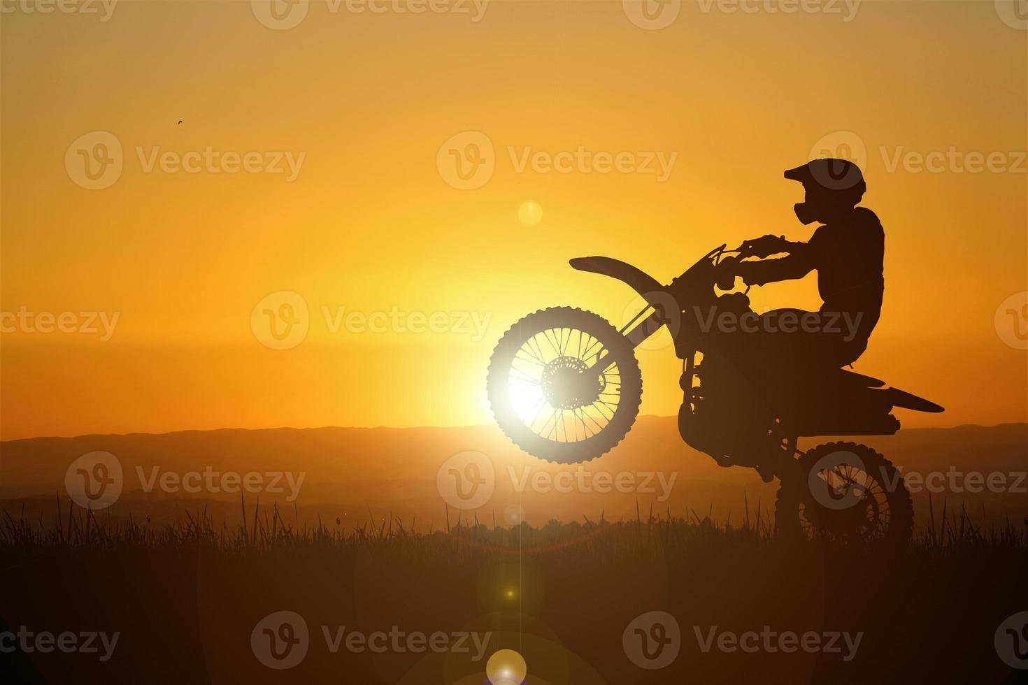 Silhouette eines Motocross-Motorrads, das das Vorderrad anhebt. Abenteuer- und Aktionskonzepte foto