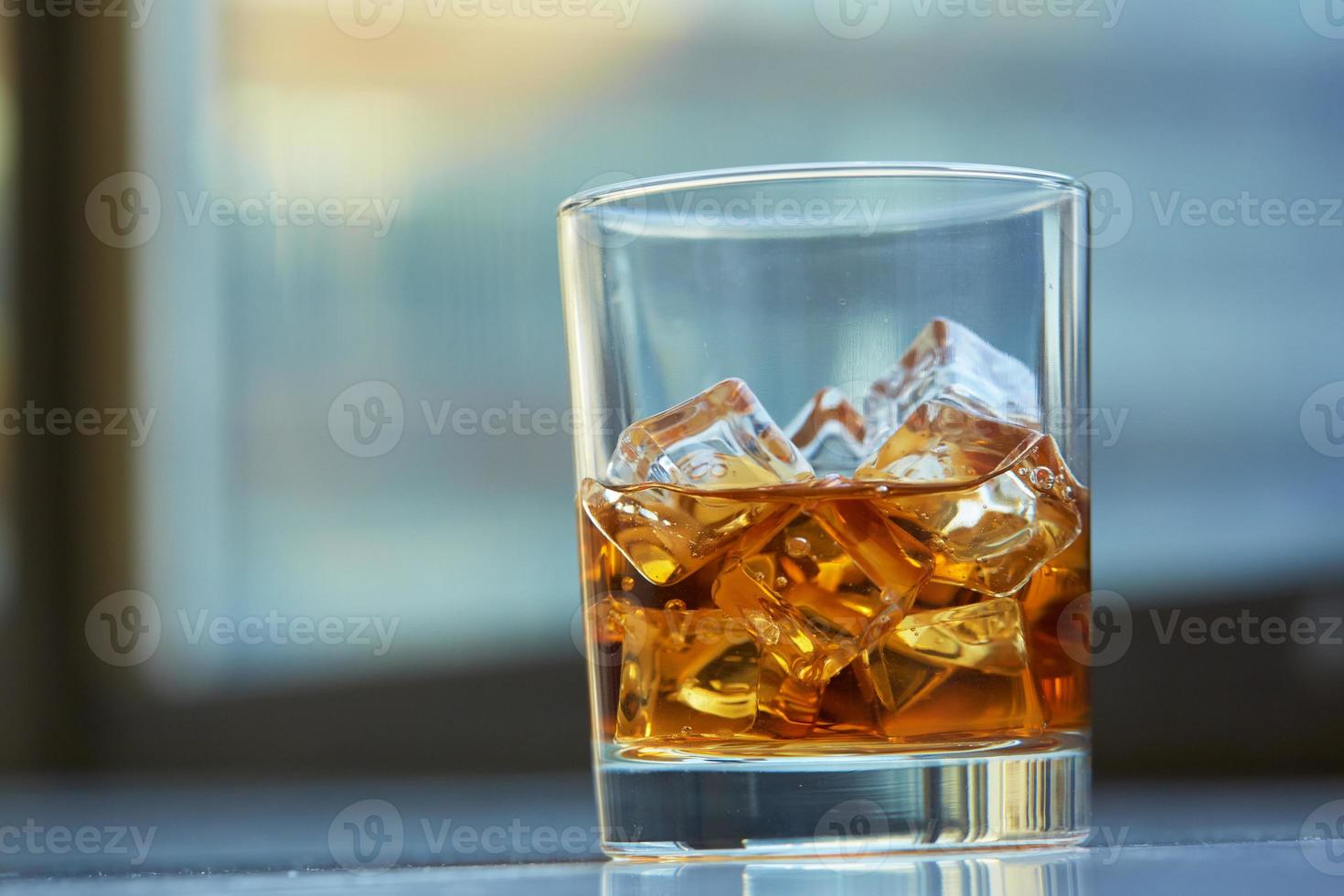 Whisky mit Eis auf einem Tisch foto