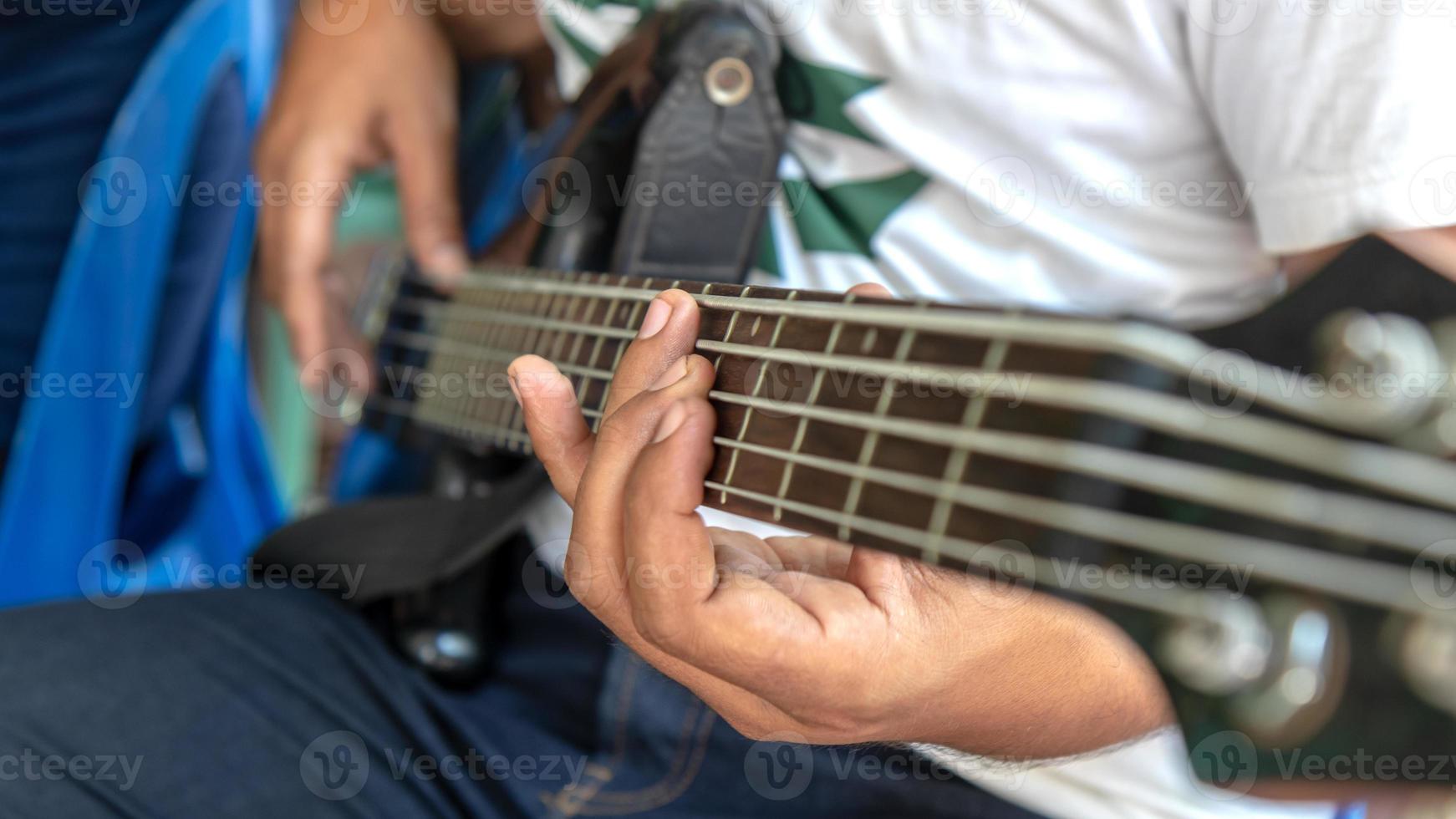 Nahaufnahmefinger und Bassgitarre. foto