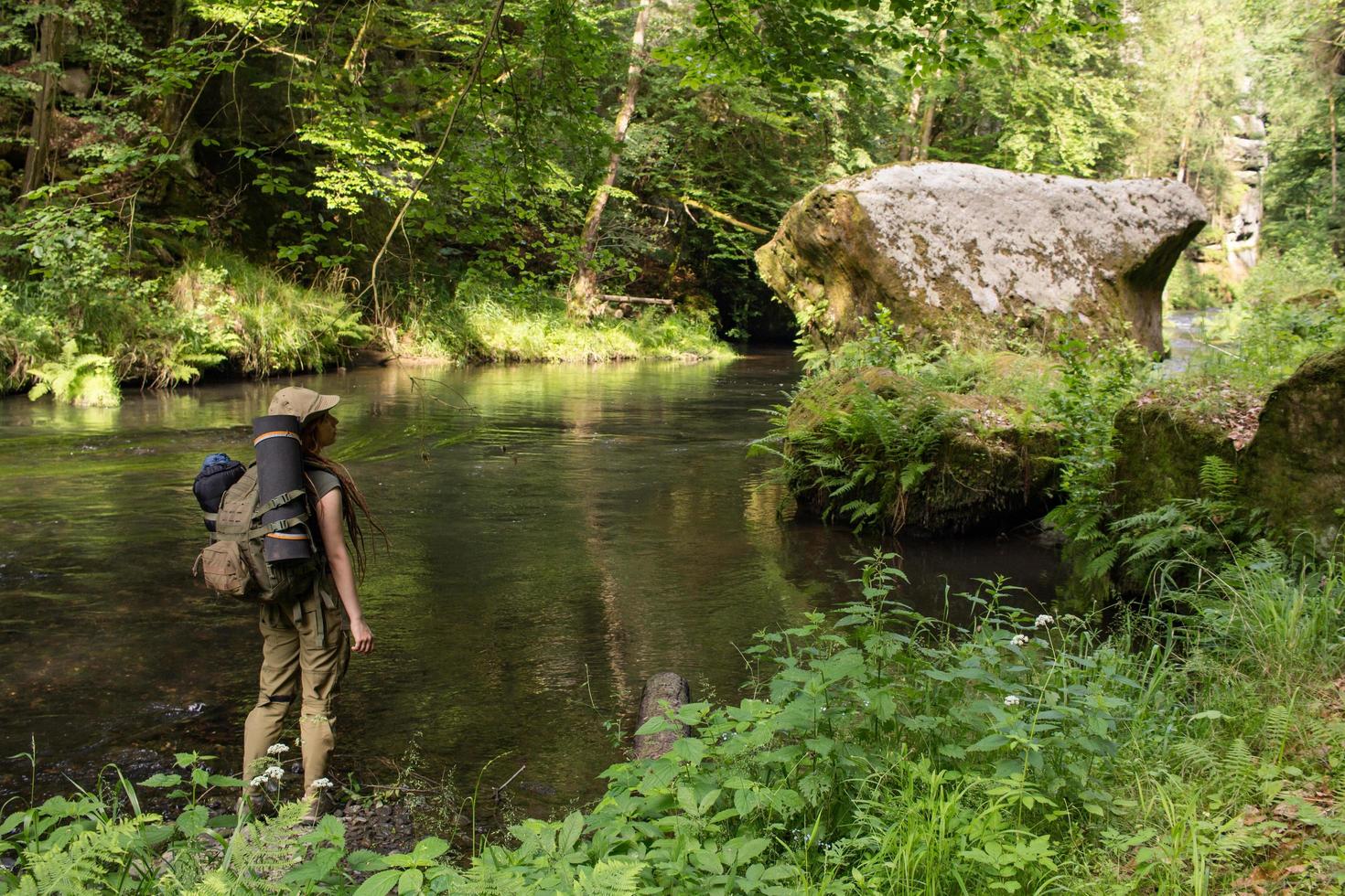 junge wandererin posiert in der nähe des flusses im nationalpark der böhmischen schweiz, reisende in den bergen der tschechischen republik foto