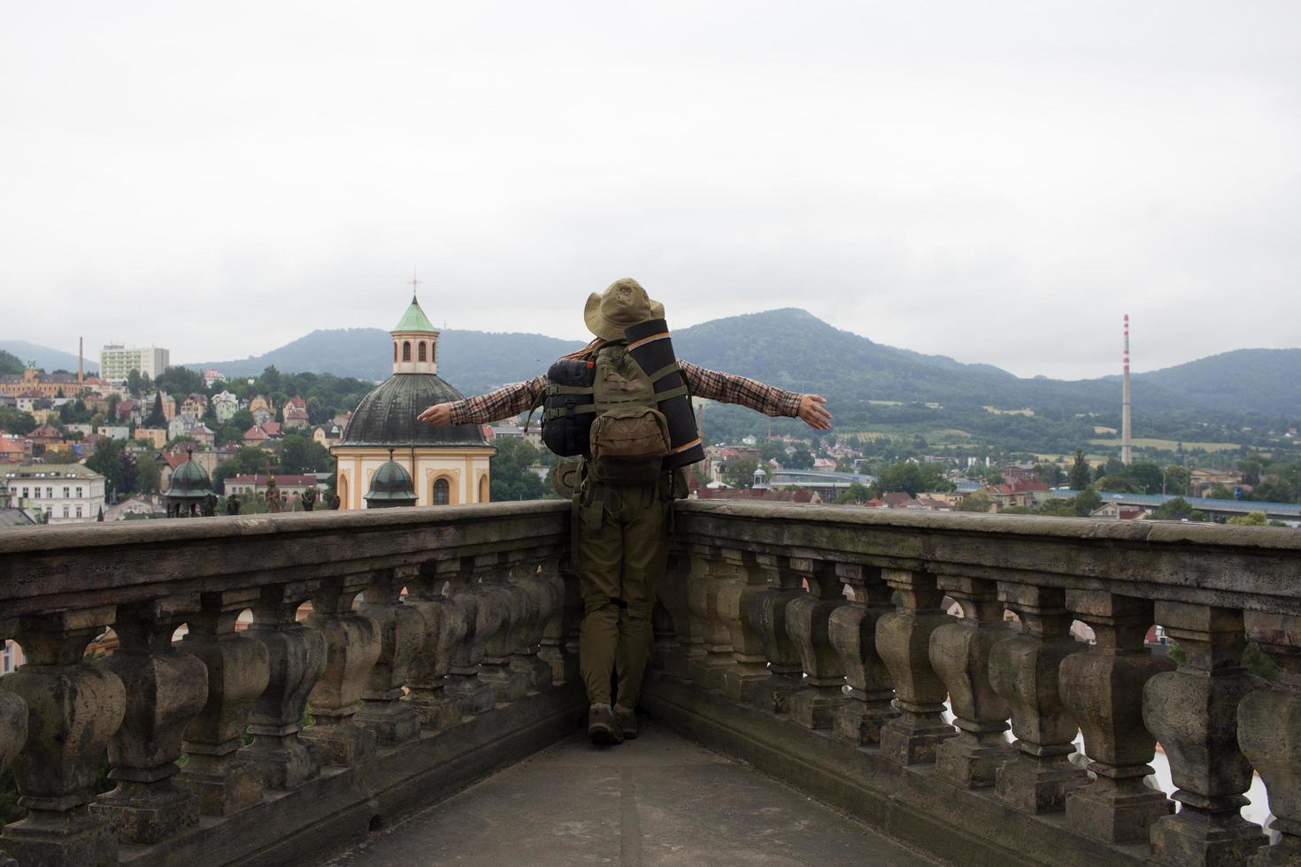 Reisender steht auf dem Balkon des Schlosses mit Blick auf die alte Eurostadt und die Berge foto