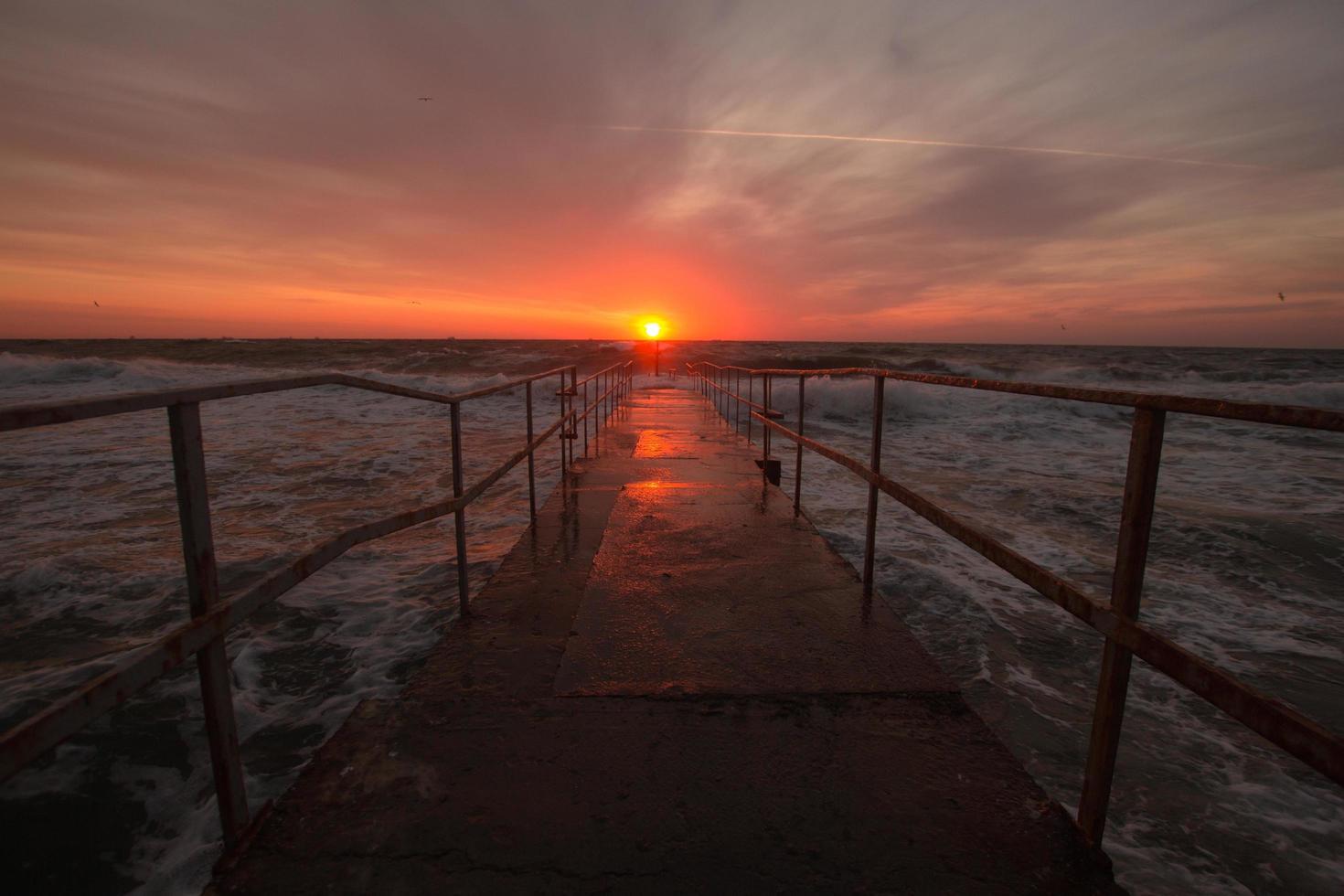 schöne meereslandschaft in der sonnenaufgangszeit, bunter rosa und orangefarbener himmel und sturm im meer. foto