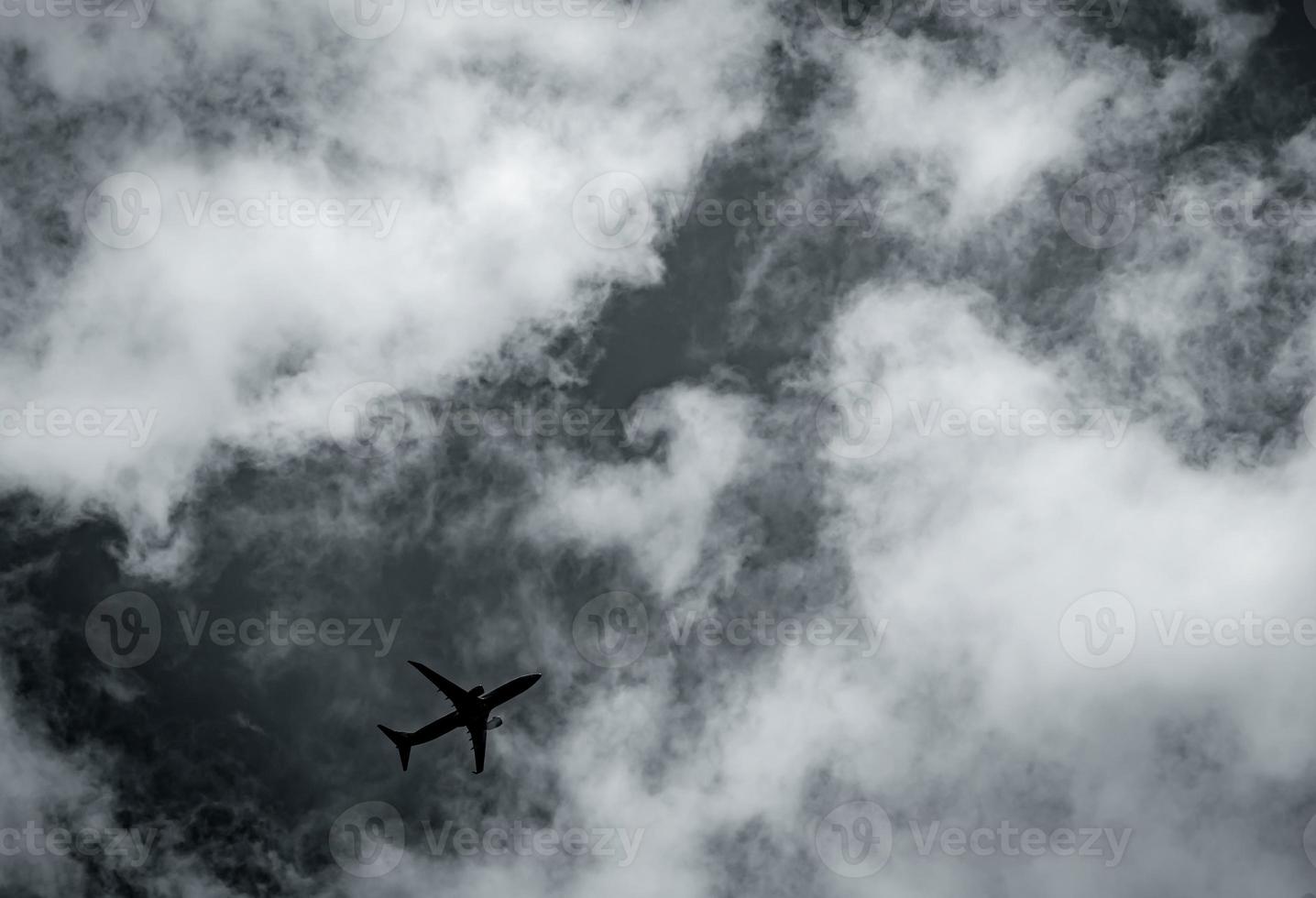 flugzeug, das auf dunklen himmel und weißen wolken fliegt. kommerzielle fluggesellschaft mit traumzielkonzept. Krisenkonzept für das Luftfahrtgeschäft. fehlgeschlagene reise urlaubsflug. Lufttransport. traurige reise. foto