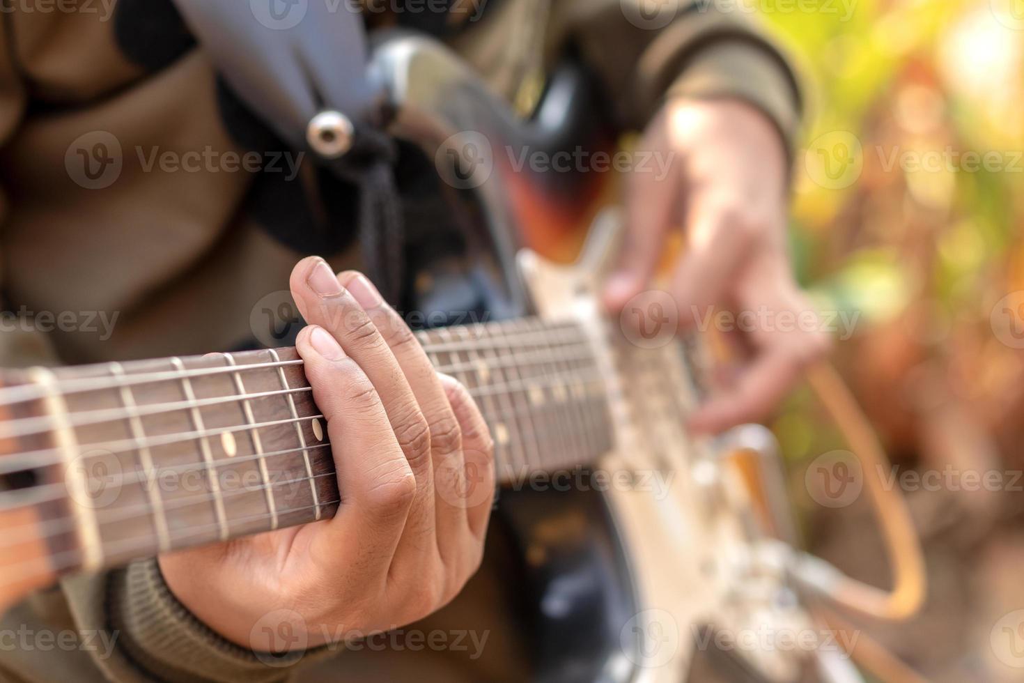 weibliche hand, die e-gitarre im freien spielt. foto