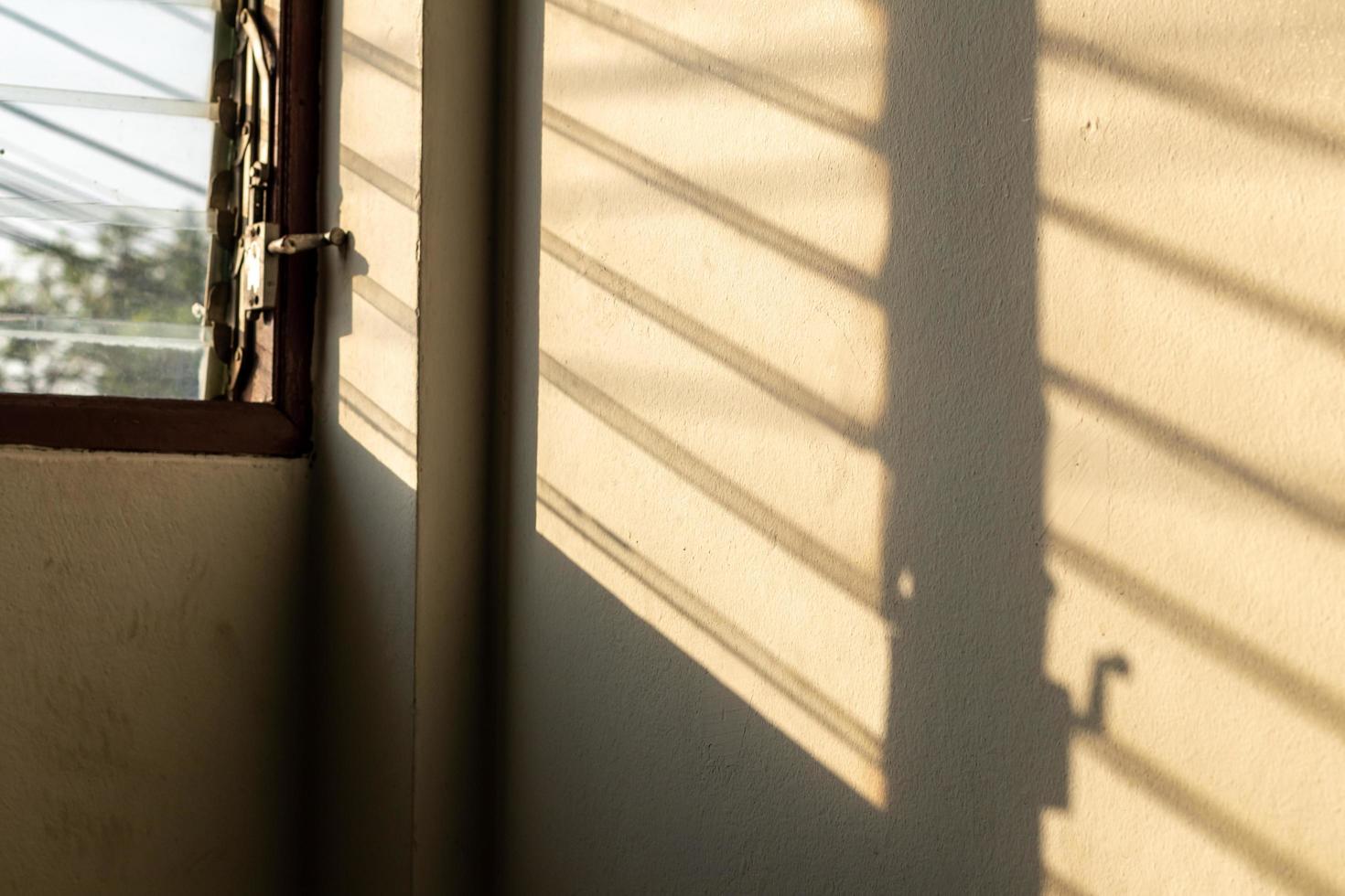 sonnenschatten an der wand mit alten lamellenfenstern. foto