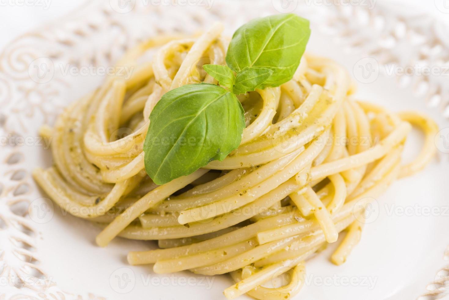 italienische Pasta Spaghetti mit Pesto-Sauce und Basilikumblatt foto
