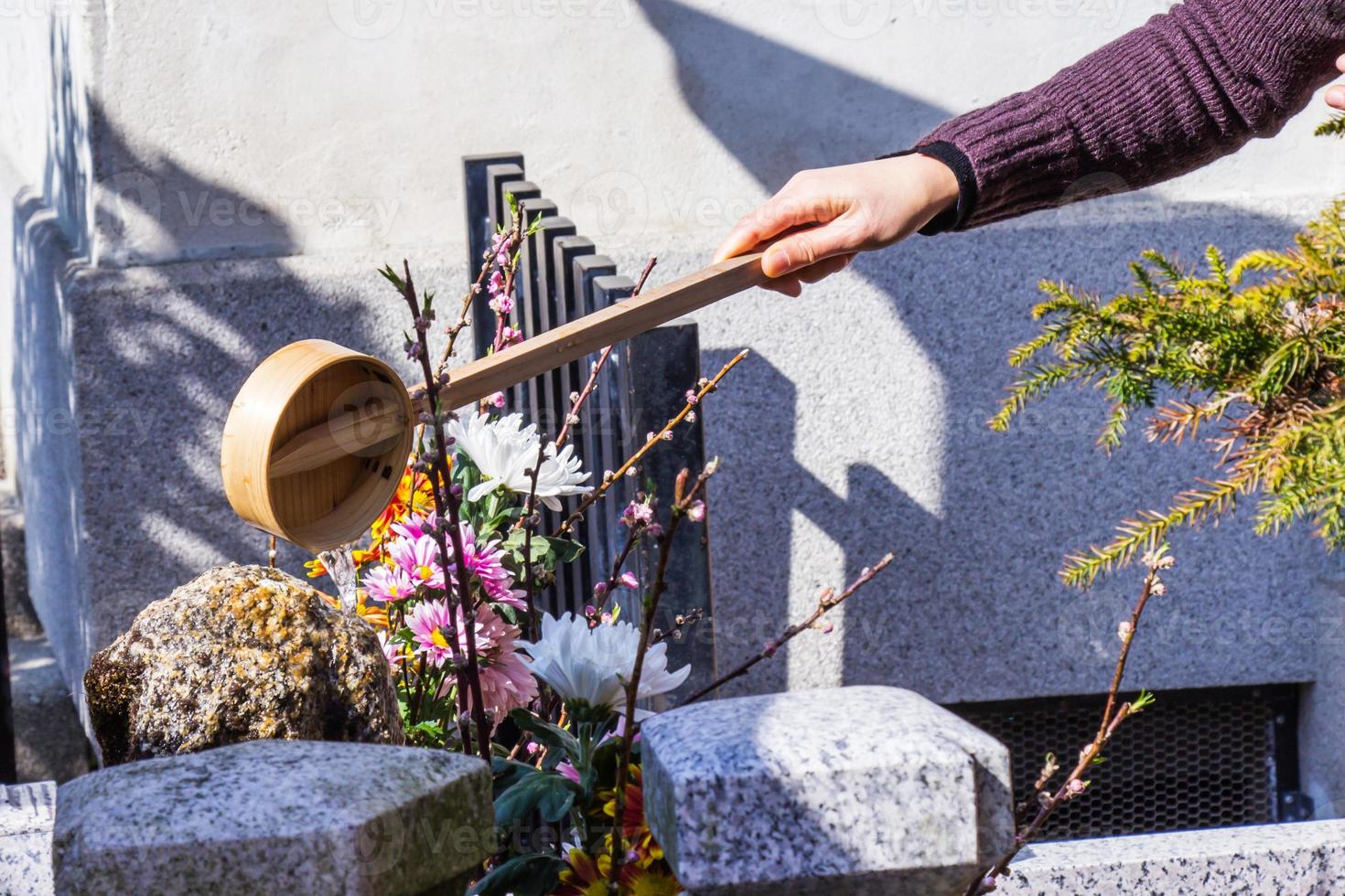 japanische touristen und ausländer besprühen sie mit tauchwasser auf einem felsen im kiyomizu-dera-tempel. Japan foto